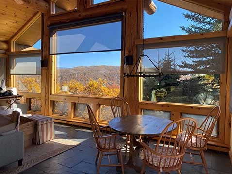 A rustic living space showcasing large windows with transparent shades
