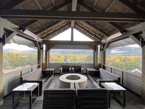 A sitting space surrounded by large windows revealing a mountain view